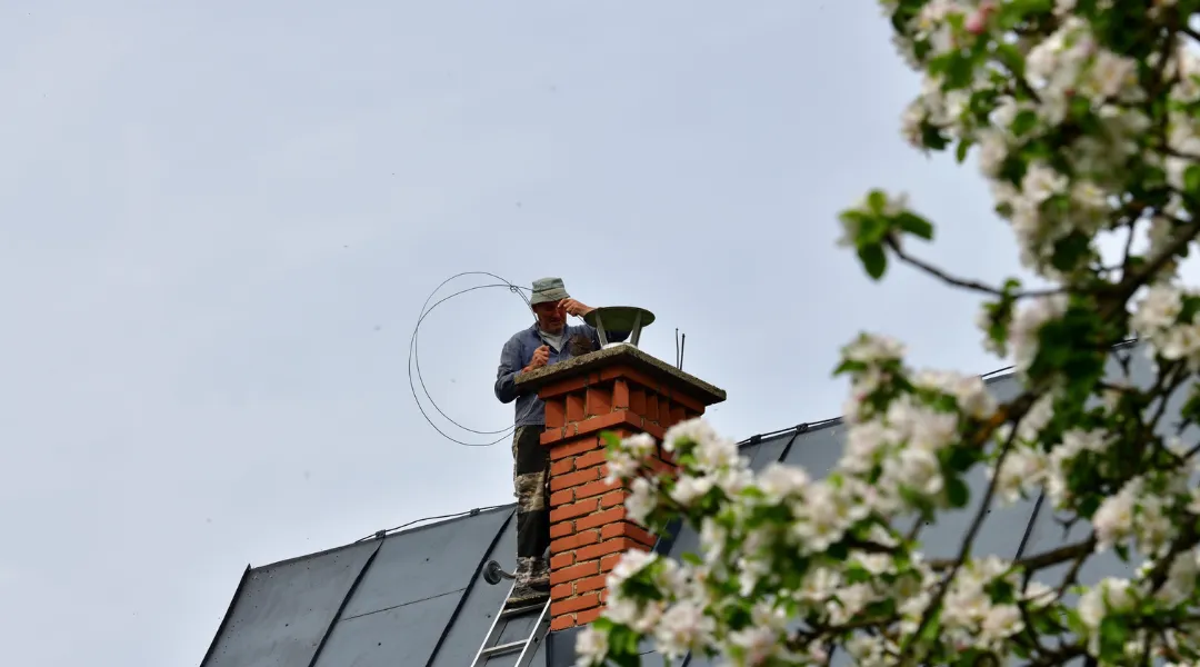 Traditional manual method of cleaning the chimney on the roof
